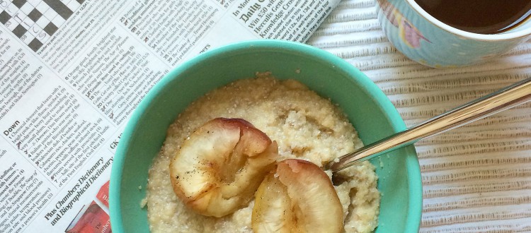 newspaper with crossword, cup of black coffee and a bowl of porridge topped with sliced peaches